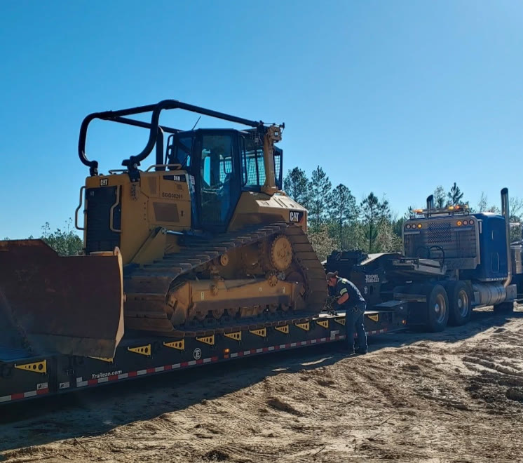 CAT D6 dozer chained down on a lowboy trailer